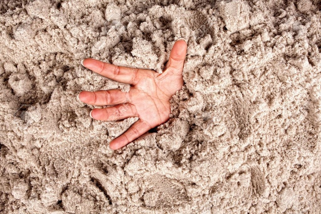 12609449-Hand-on-a-beach-sinking-or-drowning-in-quicksand-Stock-Photo-quicksand-despair-panic.jpg